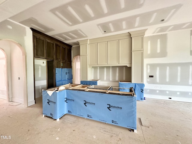 7000 N Ridge Dr, Raleigh, NC 27615 - kitchen featuring arched walkways, a center island, and dark brown cabinets