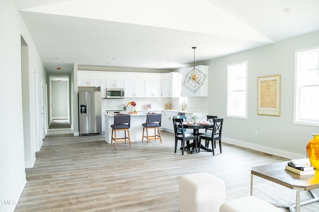 dining room with lofted ceiling and light hardwood / wood-style flooring