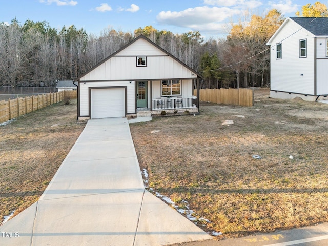 view of front of home featuring driveway, a garage, fence, a porch, and board and batten siding