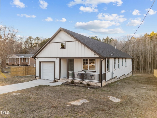 view of front of home featuring a shingled roof, covered porch, fence, a garage, and driveway