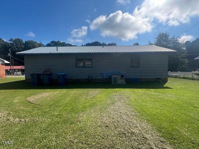 back of house with a yard and central air condition unit