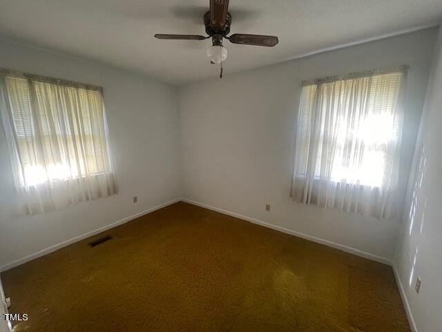 carpeted spare room with ceiling fan