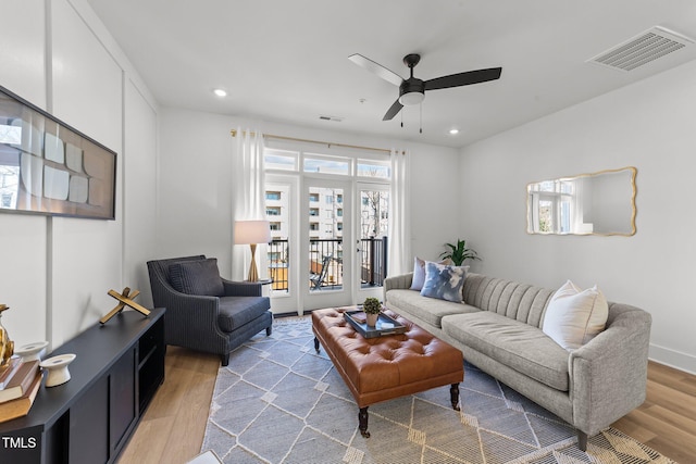 living room featuring light wood-type flooring and ceiling fan