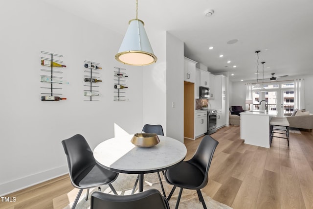 dining space with light wood-type flooring and sink