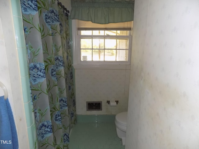 bathroom featuring toilet and tile patterned flooring