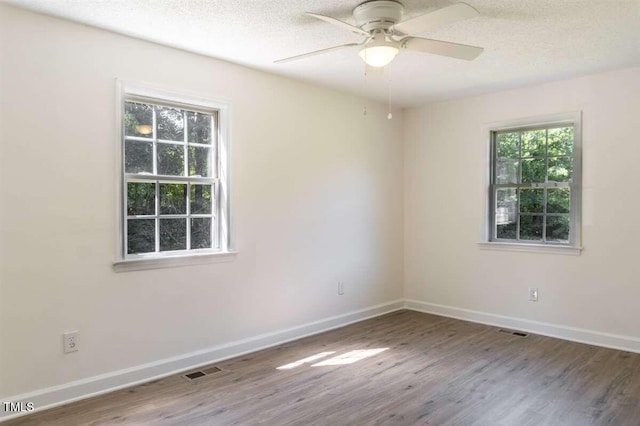 empty room featuring ceiling fan, hardwood / wood-style flooring, and a textured ceiling