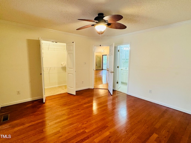 unfurnished bedroom featuring ceiling fan, wood-type flooring, a textured ceiling, and a closet