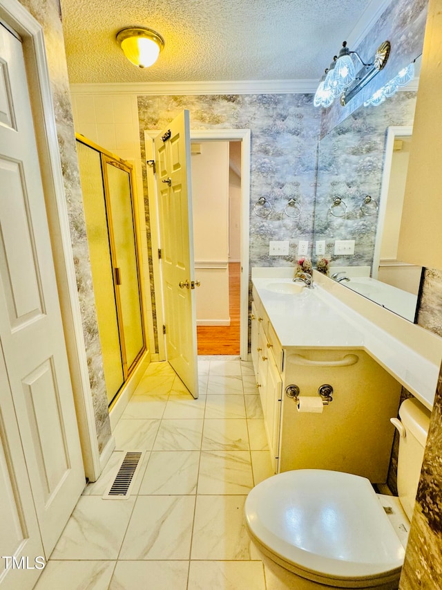 bathroom with ornamental molding, a textured ceiling, vanity, an enclosed shower, and toilet