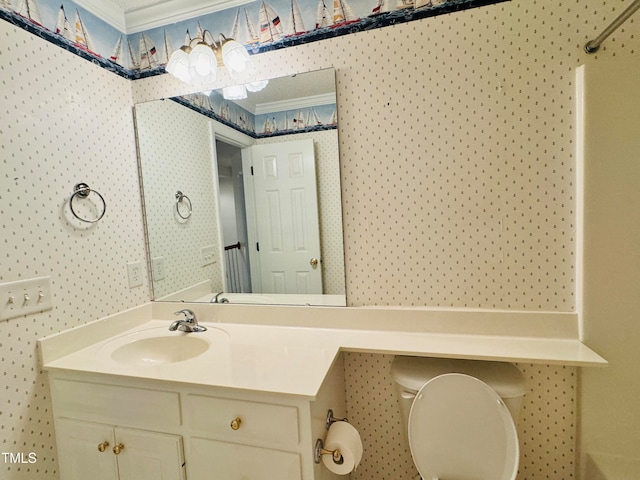 bathroom with toilet, vanity, and crown molding