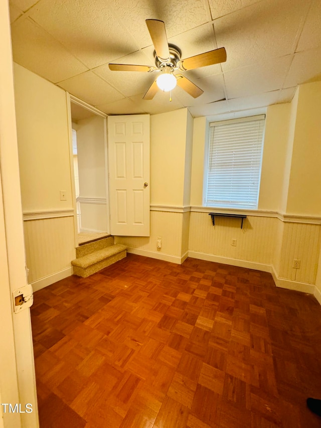 unfurnished room featuring a paneled ceiling and ceiling fan