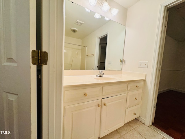 bathroom featuring vanity, walk in shower, and tile patterned flooring