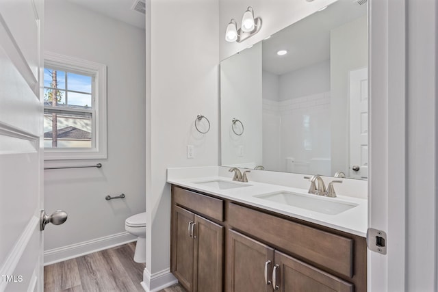 bathroom with hardwood / wood-style floors, vanity, and toilet