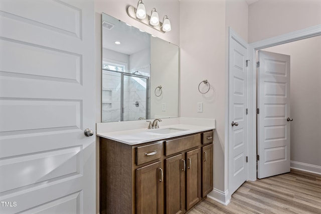 bathroom featuring vanity, hardwood / wood-style flooring, and an enclosed shower