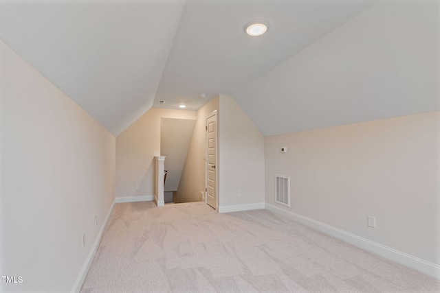 additional living space with light carpet and vaulted ceiling