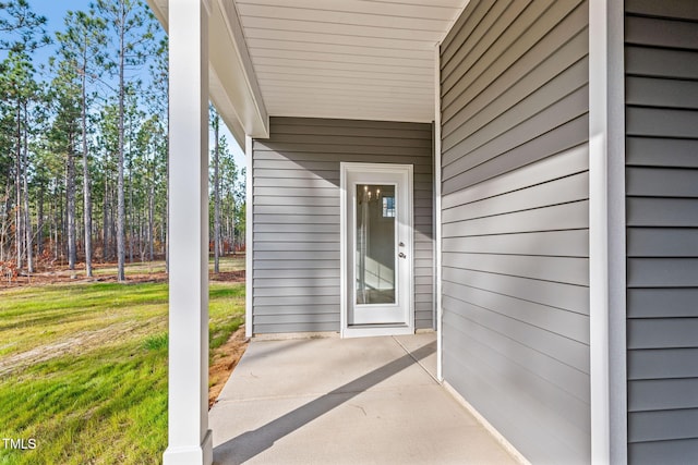 view of exterior entry featuring a lawn