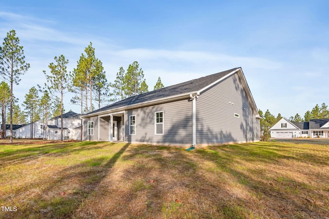 rear view of property featuring a yard