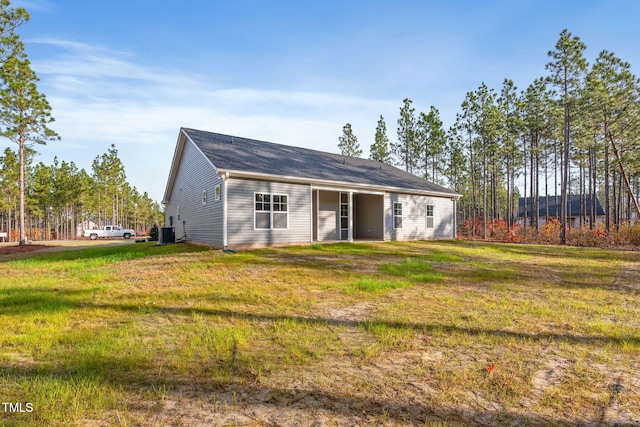 view of front of home with cooling unit and a front lawn