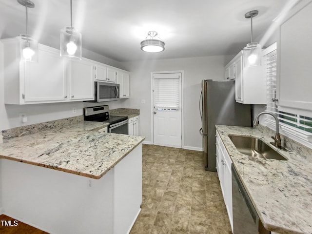 kitchen featuring pendant lighting, sink, kitchen peninsula, white cabinetry, and stainless steel appliances