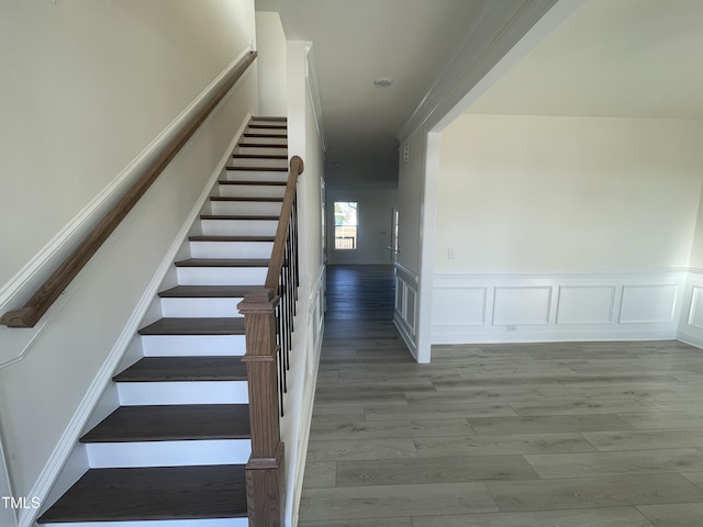 staircase with hardwood / wood-style floors and crown molding