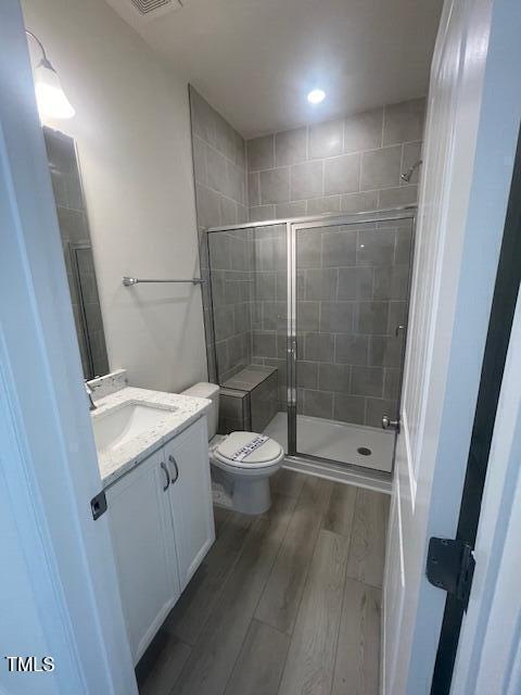 1528 Maelyn Way, Fuquay Varina, NC 27526 - full bath with wood finished floors, vanity, toilet, a stall shower, and recessed lighting
