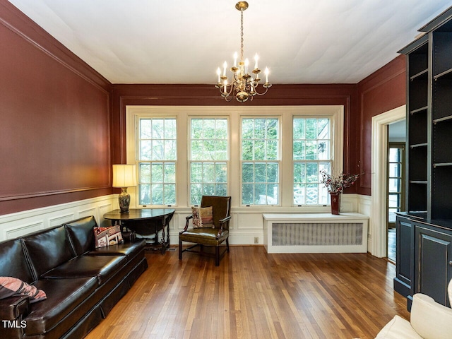 living room featuring radiator, plenty of natural light, dark wood-type flooring, and a notable chandelier