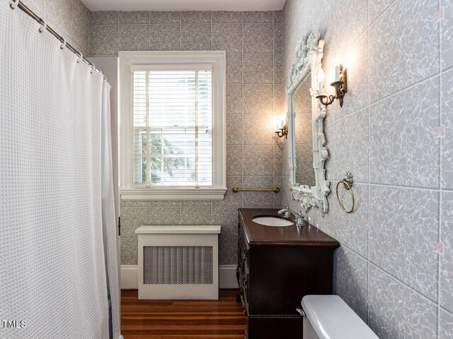 bathroom featuring vanity, hardwood / wood-style flooring, toilet, and walk in shower