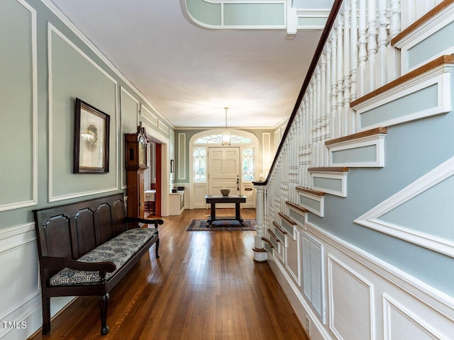 foyer with dark hardwood / wood-style flooring and ornamental molding