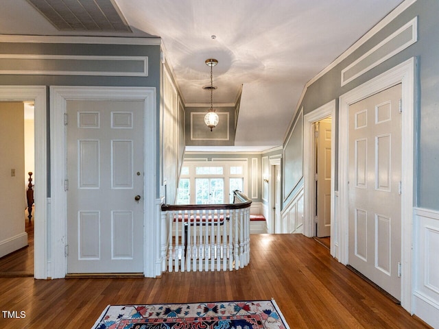 foyer entrance with wood-type flooring and crown molding