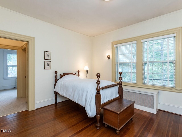 bedroom featuring radiator heating unit and dark wood-type flooring