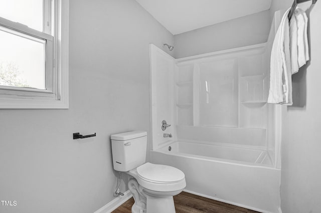 bathroom with wood-type flooring, toilet, and bathing tub / shower combination