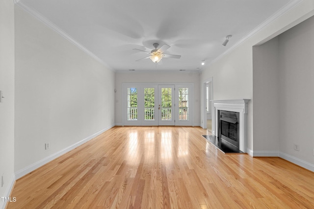 unfurnished living room featuring crown molding, french doors, ceiling fan, and light wood-type flooring