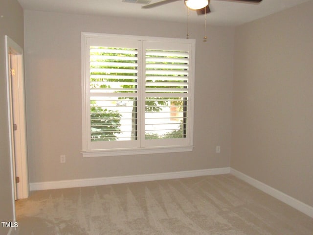 carpeted spare room featuring ceiling fan