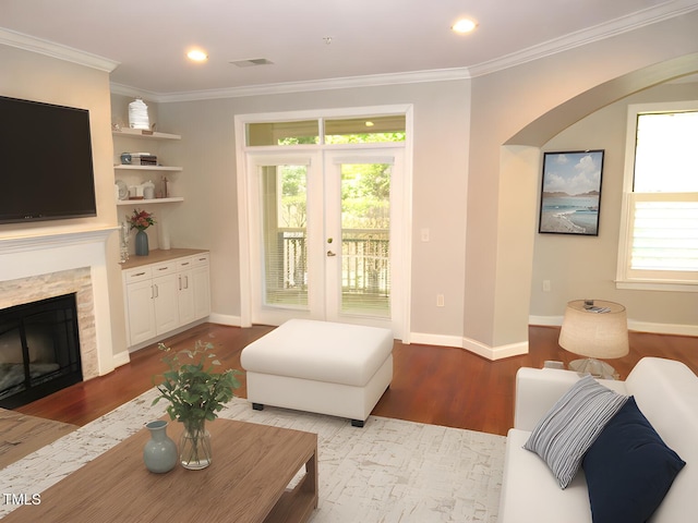 living room featuring crown molding, a stone fireplace, and light hardwood / wood-style floors