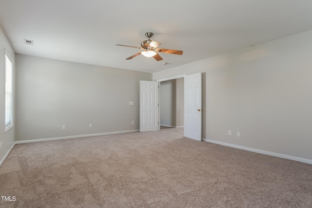 spare room featuring light colored carpet and ceiling fan