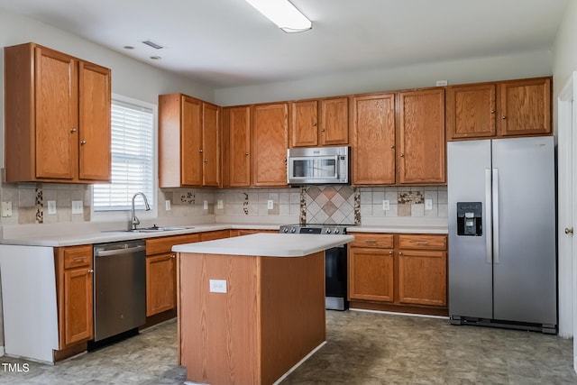 kitchen featuring decorative backsplash, appliances with stainless steel finishes, sink, and a kitchen island