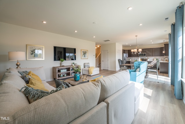 living room featuring an inviting chandelier and light wood-type flooring