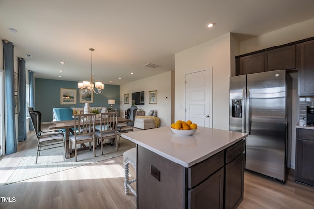 kitchen featuring dark brown cabinetry, a center island, light hardwood / wood-style flooring, stainless steel refrigerator with ice dispenser, and a notable chandelier