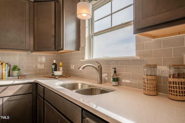 kitchen with decorative backsplash, dark brown cabinets, and sink