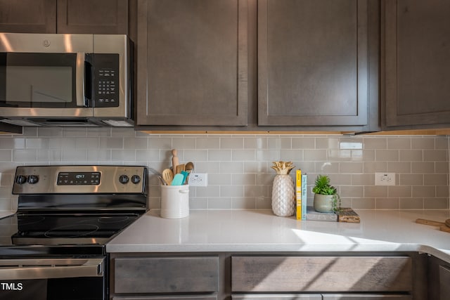 kitchen with decorative backsplash, dark brown cabinetry, and stainless steel appliances