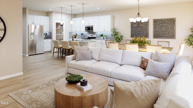 living room with light hardwood / wood-style flooring and an inviting chandelier