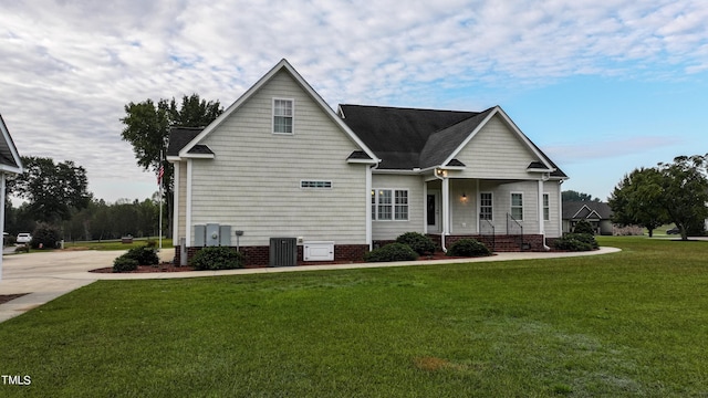 view of front facade with cooling unit, a porch, and a front yard