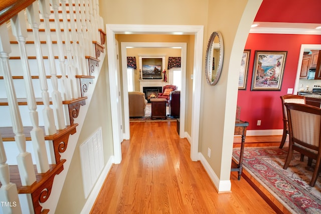 hallway featuring light hardwood / wood-style flooring and ornamental molding