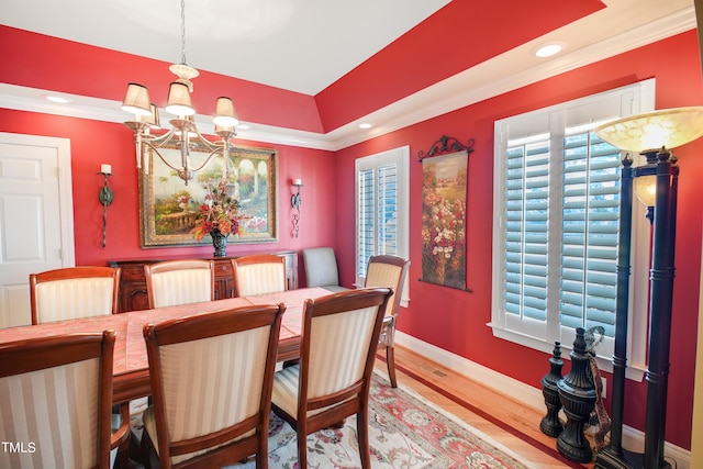 dining room featuring an inviting chandelier, hardwood / wood-style flooring, and ornamental molding