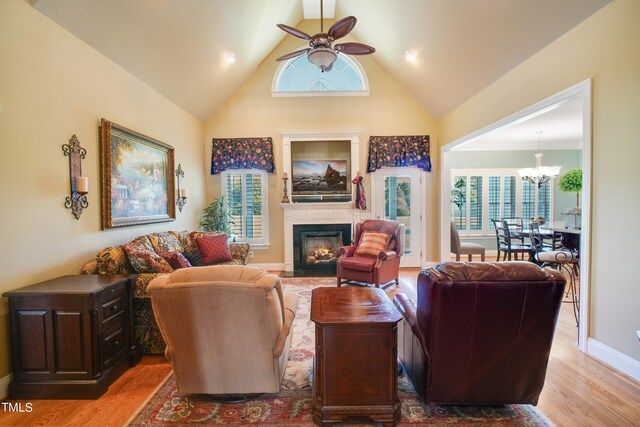 living room featuring ceiling fan with notable chandelier, light wood-type flooring, and a healthy amount of sunlight