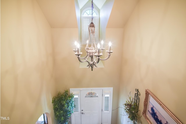 entryway featuring vaulted ceiling, a chandelier, and plenty of natural light