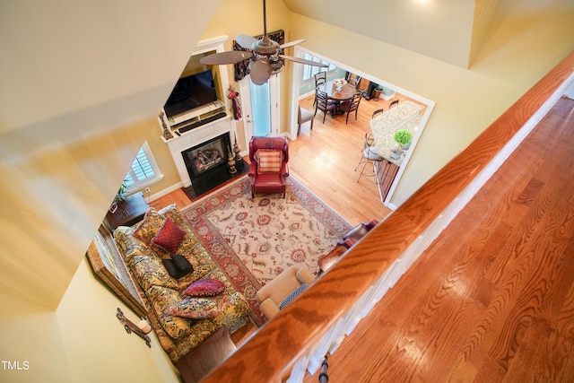 living room with high vaulted ceiling, ceiling fan, and hardwood / wood-style floors