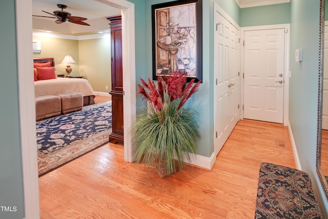 hallway featuring light wood-type flooring and ornamental molding