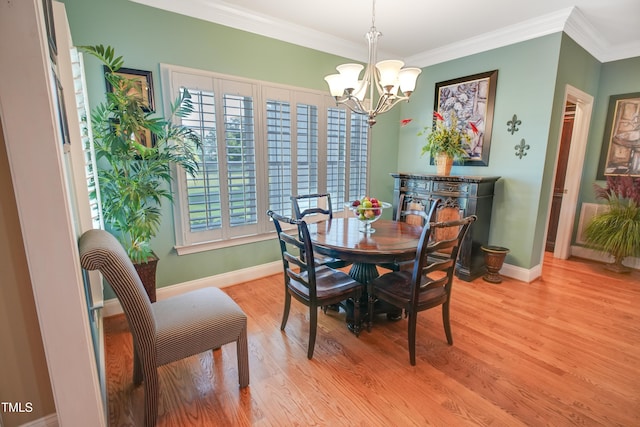 dining space with light wood-type flooring, crown molding, and a notable chandelier