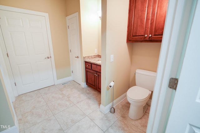 bathroom featuring vanity, tile patterned flooring, and toilet