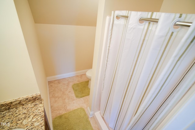 bathroom featuring a shower with shower curtain and toilet